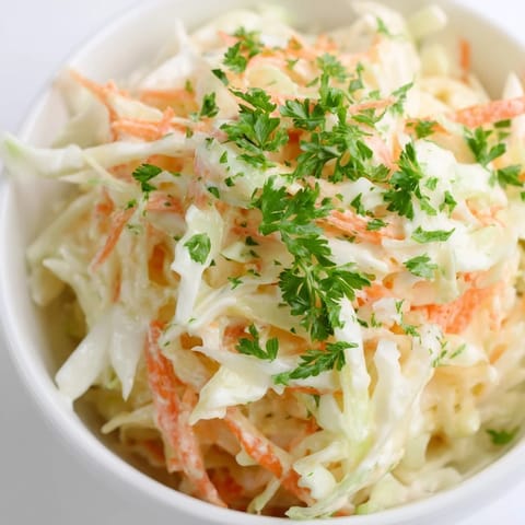 Homemade Coleslaw with Apple served in a vibrant bowl; a refreshing side dish with a tangy, sweet flavor.